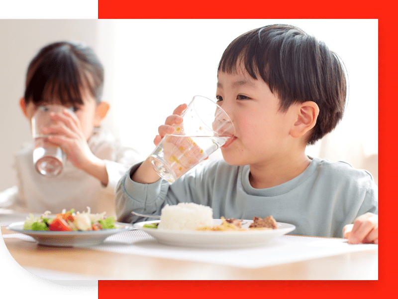 Two young kids drinking water
